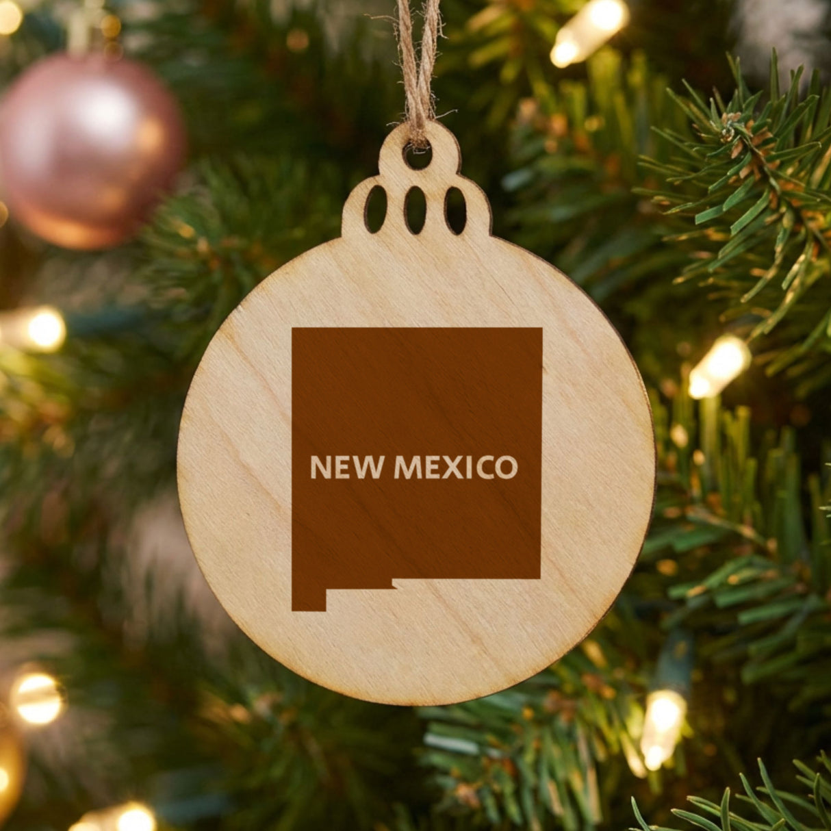 New Mexico round wood Christmas ornament engraved with the state shape and NEW MEXICO in bold lettering