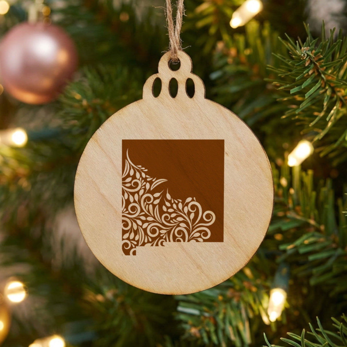 New Mexico round wood Christmas ornament engraved with the state shape in ornate floral scrollwork