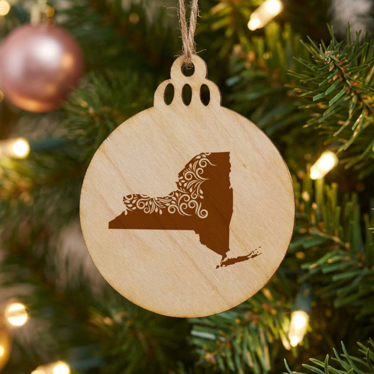 New York round wood Christmas ornament engraved with the state shape in ornate floral scrollwork
