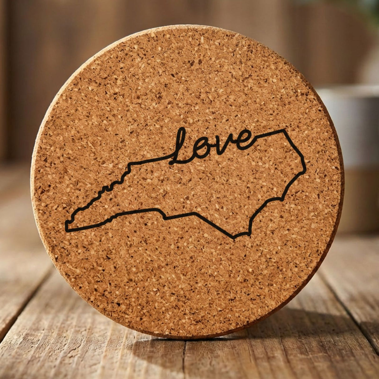 North Carolina round cork coaster engraved with a hand-drawn state outline and love in cursive