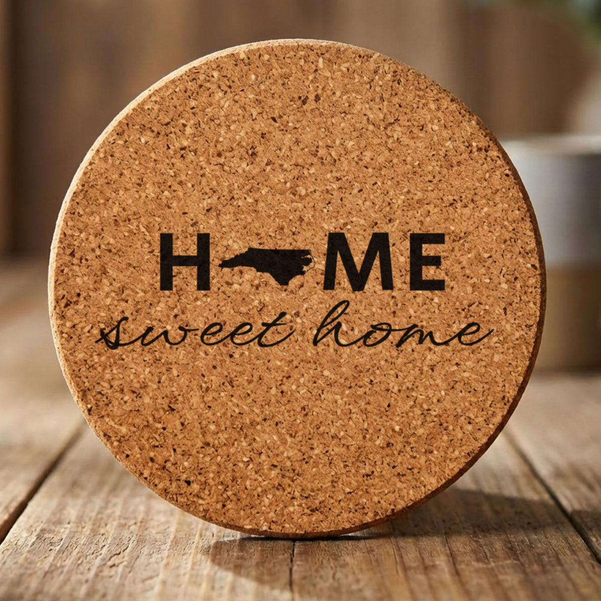 North Carolina round cork coaster engraved with HOME sweet home using the state shape as the letter O