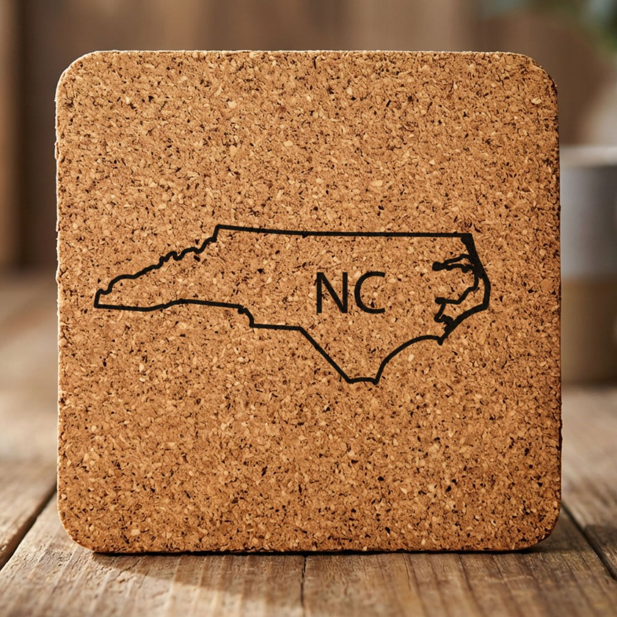 North Carolina square cork coaster engraved with the state outline and NC initials