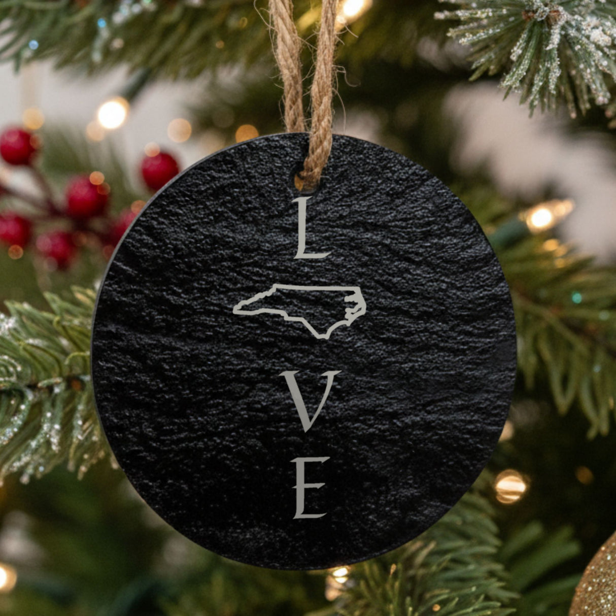 North Carolina round slate Christmas ornament engraved with LOVE stacked vertically using the state as the letter O