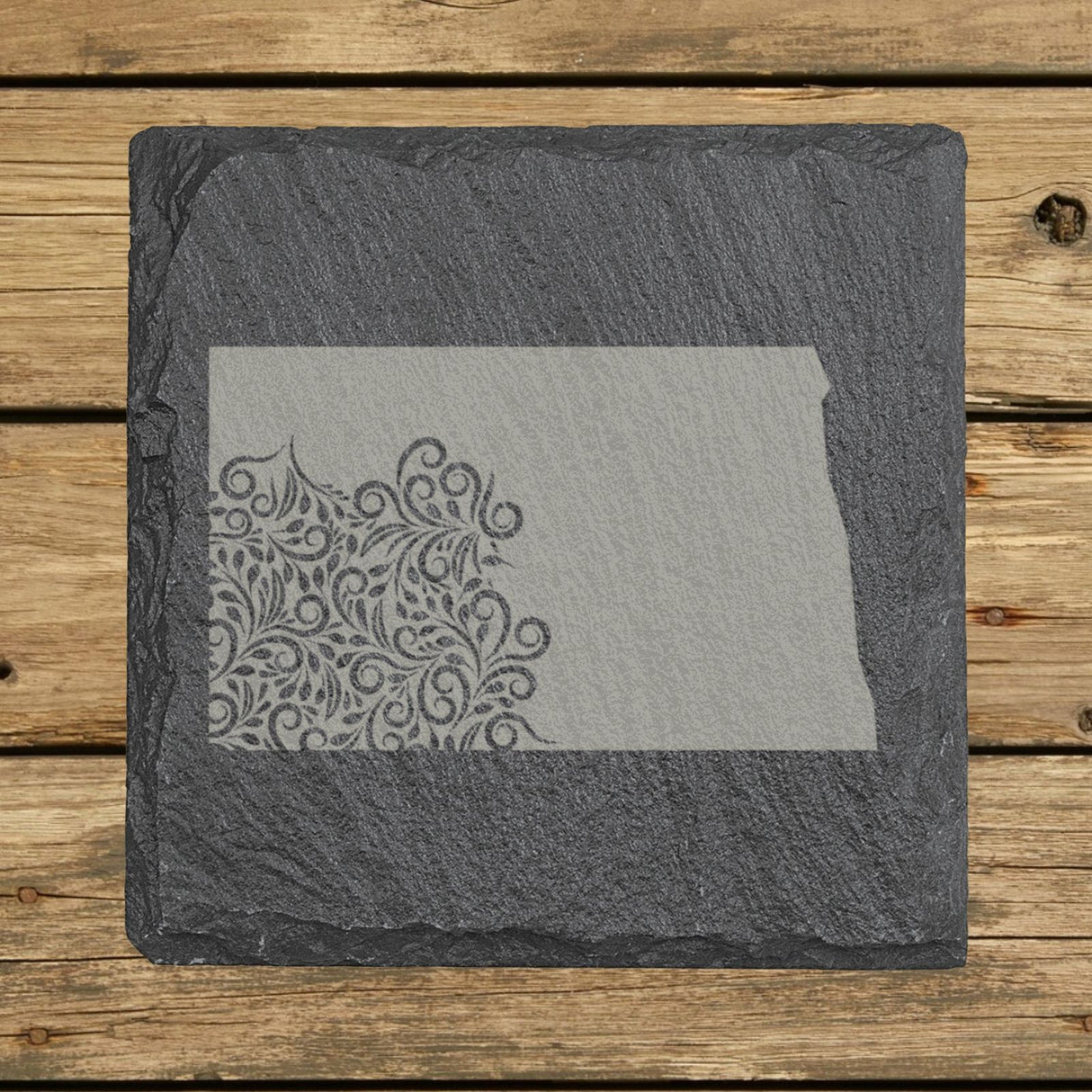 North Dakota square slate coaster engraved with the state shape in ornate floral scrollwork