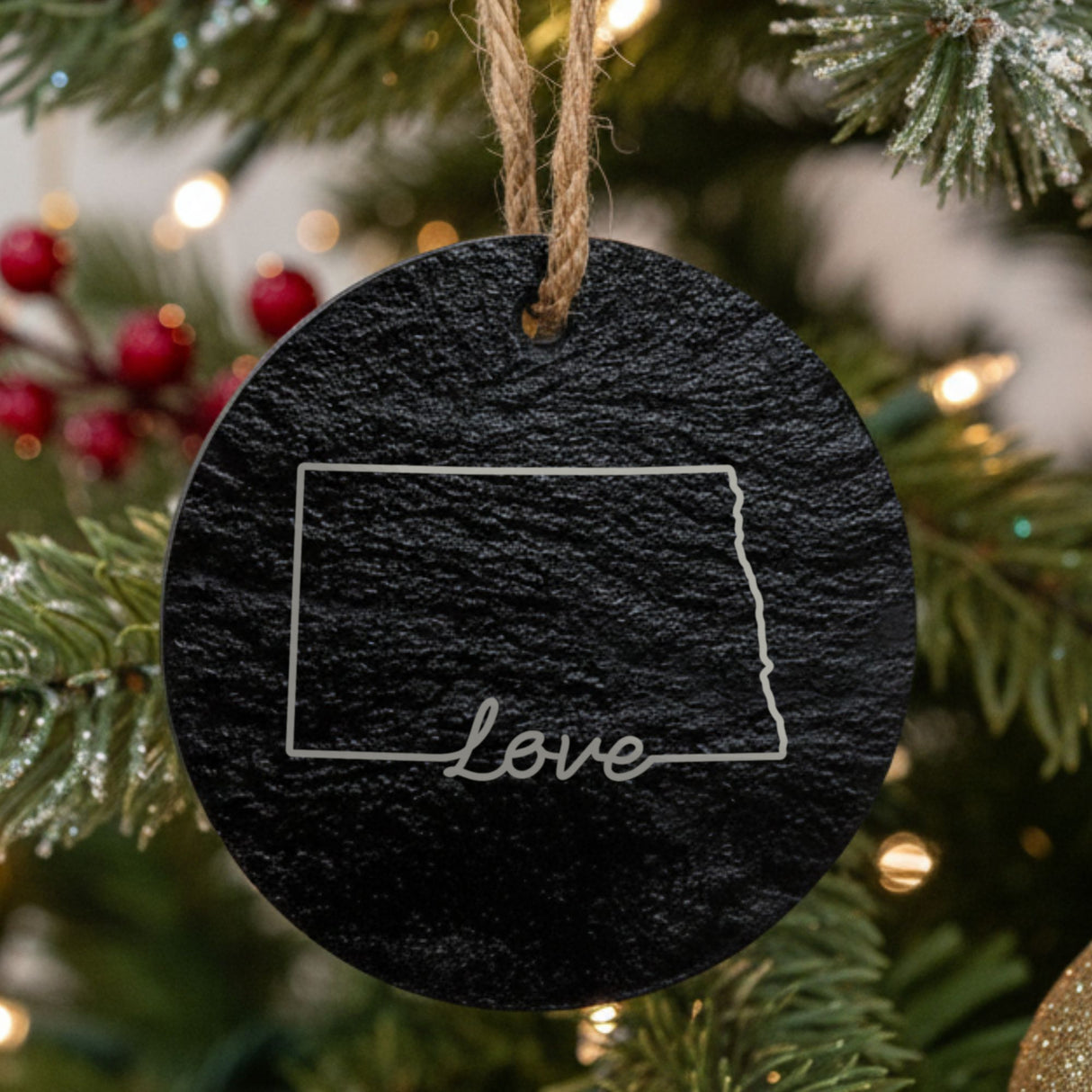 North Dakota round slate Christmas ornament engraved with a hand-drawn state outline and love in cursive