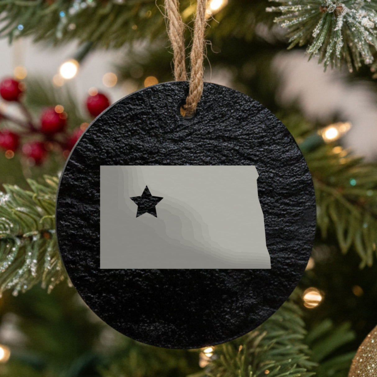North Dakota round slate Christmas ornament engraved with the state shape and a star