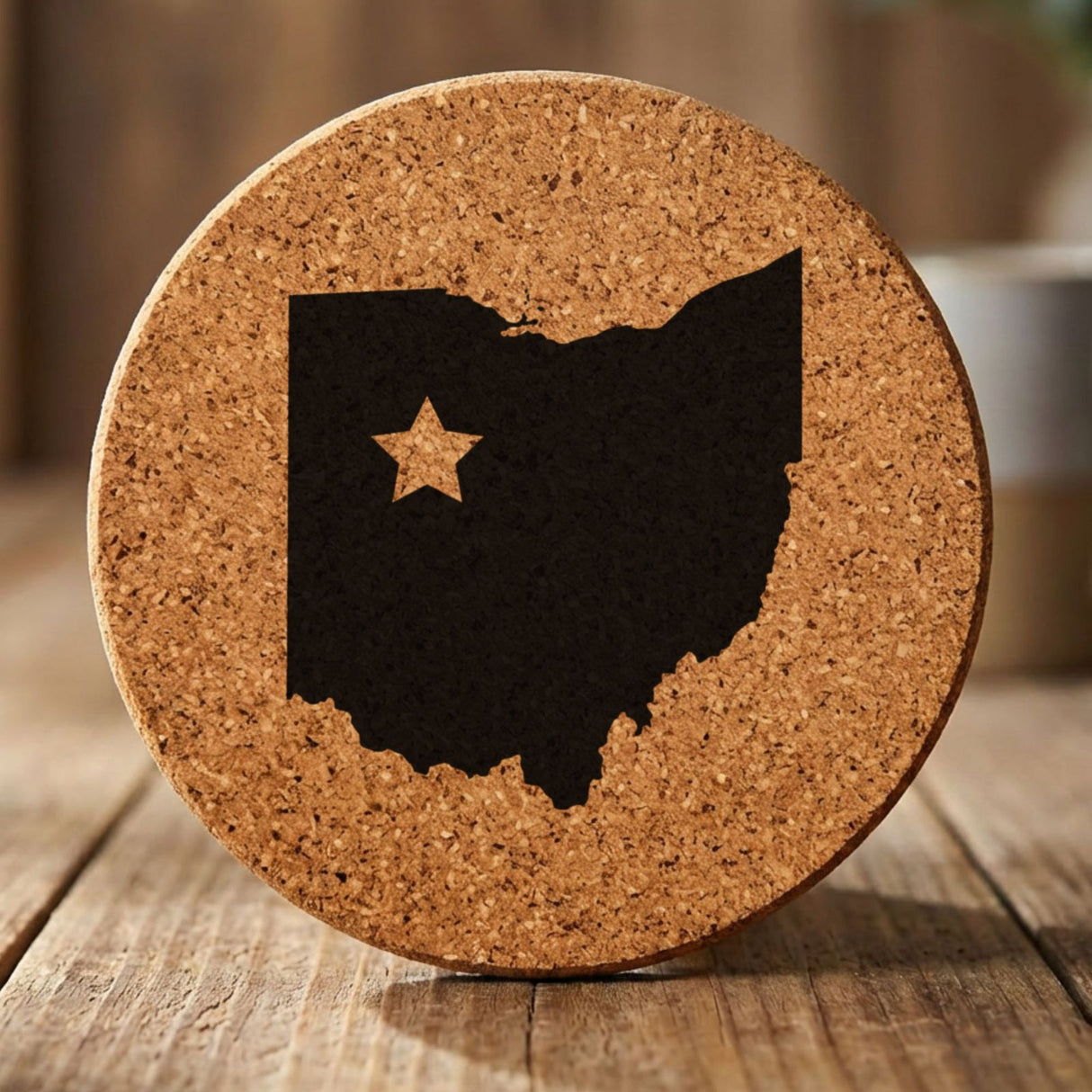 Ohio round cork coaster engraved with the state shape and a star
