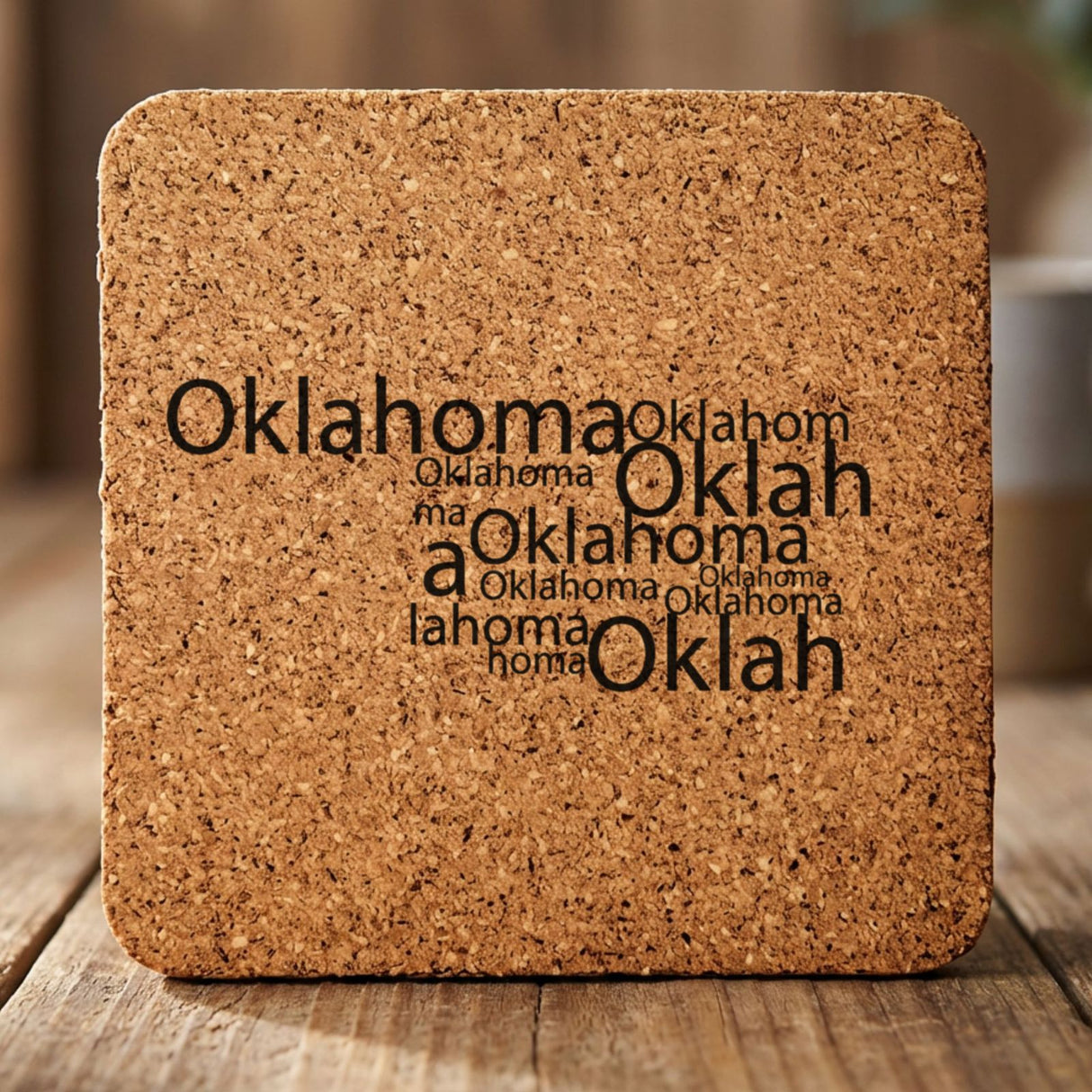 Oklahoma square cork coaster engraved with a word cloud of repeating Oklahoma text