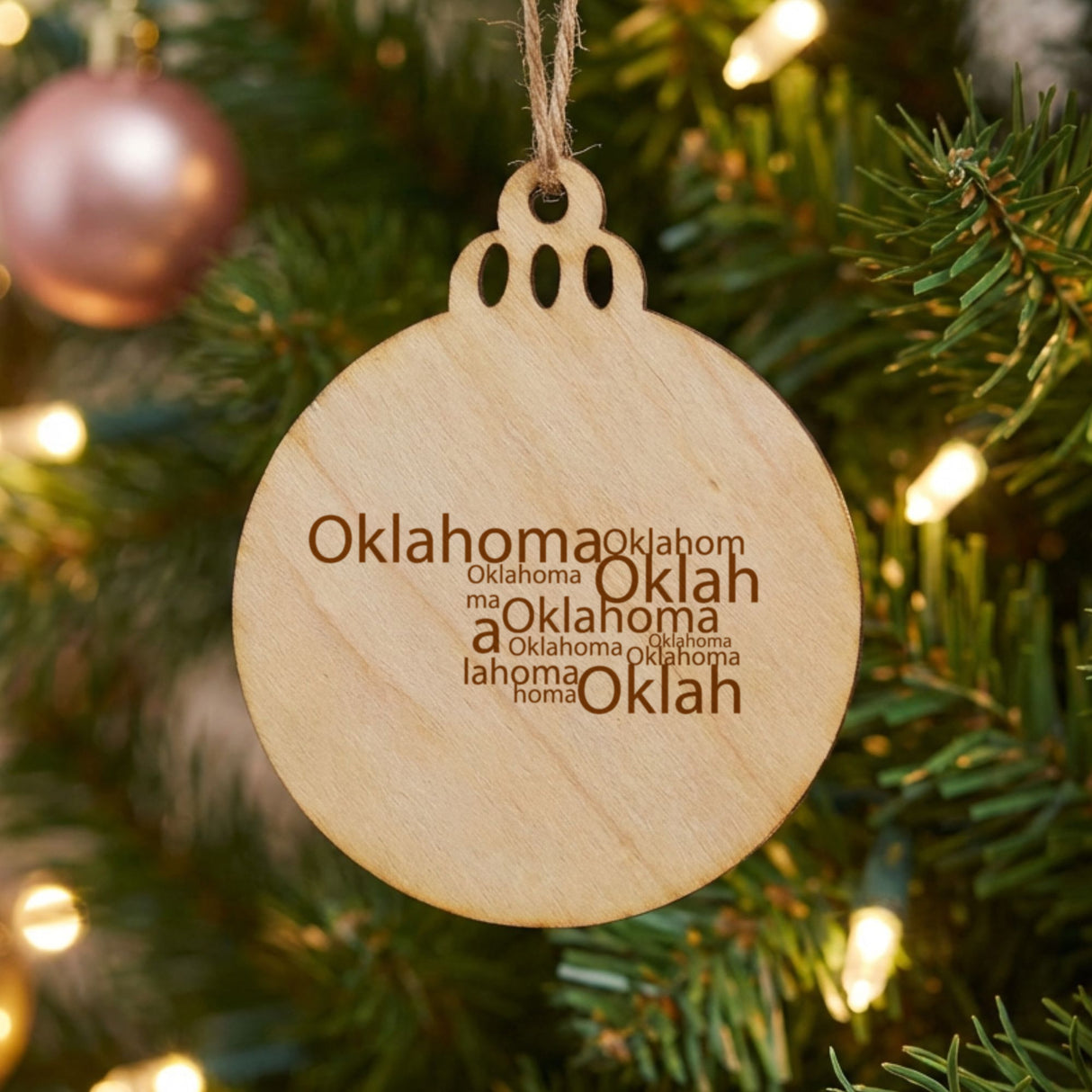Oklahoma round wood Christmas ornament engraved with a word cloud of repeating Oklahoma text