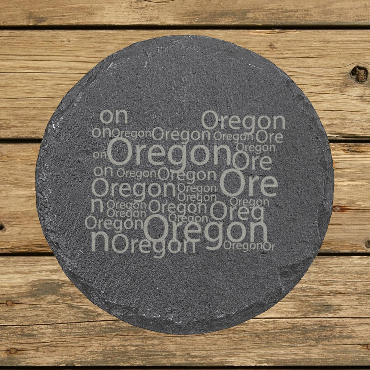 Oregon round slate coaster engraved with a word cloud of repeating Oregon text