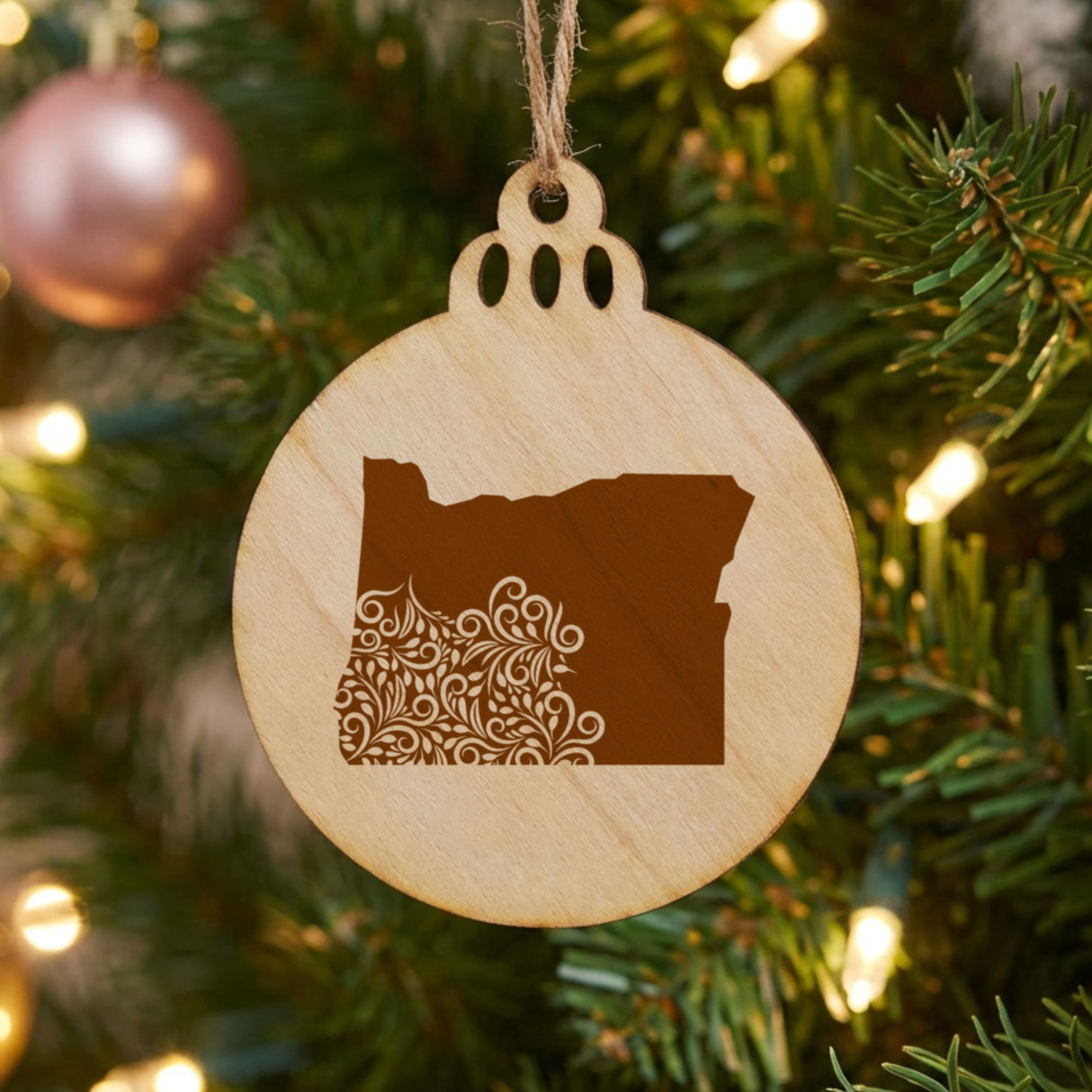 Oregon round wood Christmas ornament engraved with the state shape in ornate floral scrollwork