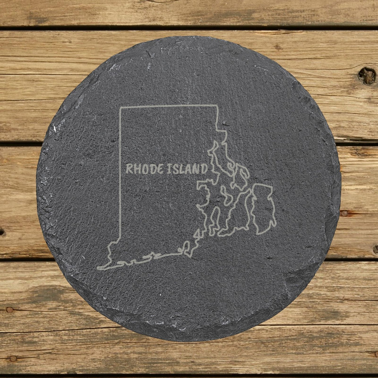Rhode Island round slate coaster engraved with the state outline and RHODE ISLAND in hand-drawn brush lettering