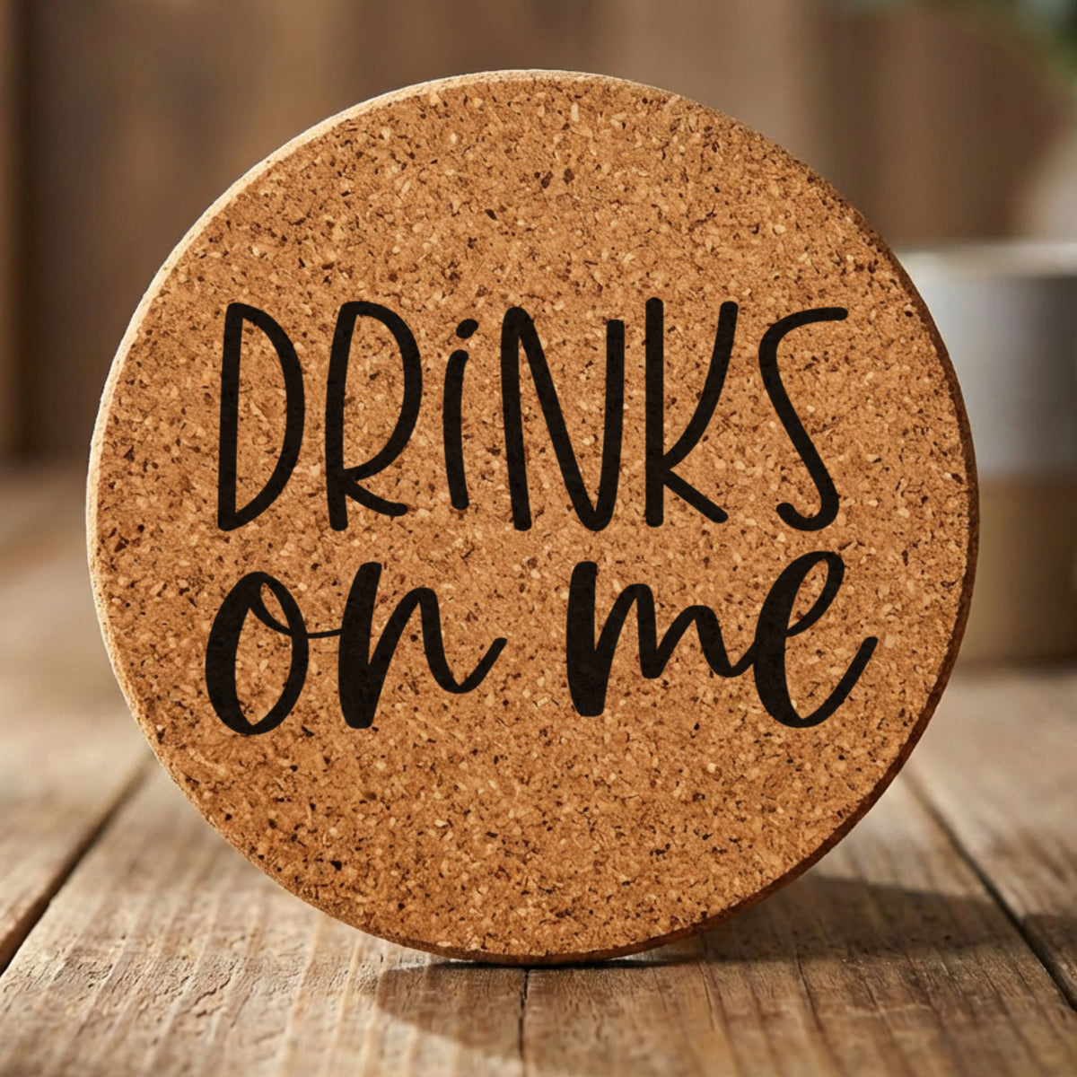 Round cork coaster laser engraved with "Drinks On Me"