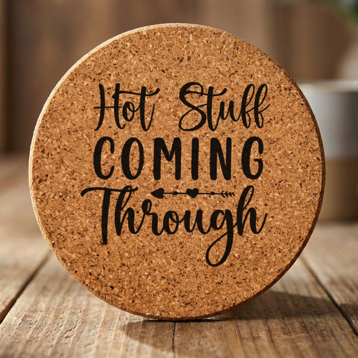 Round cork coaster laser engraved with "Hot Stuff Coming Through"