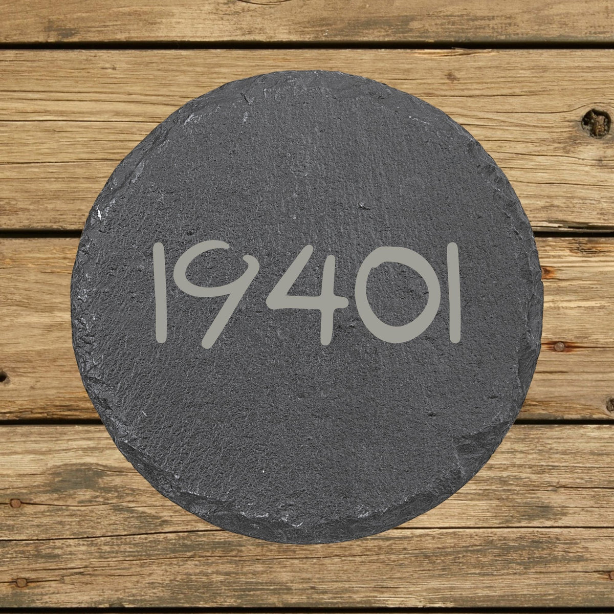 Round slate coaster laser engraved with a custom zip code design