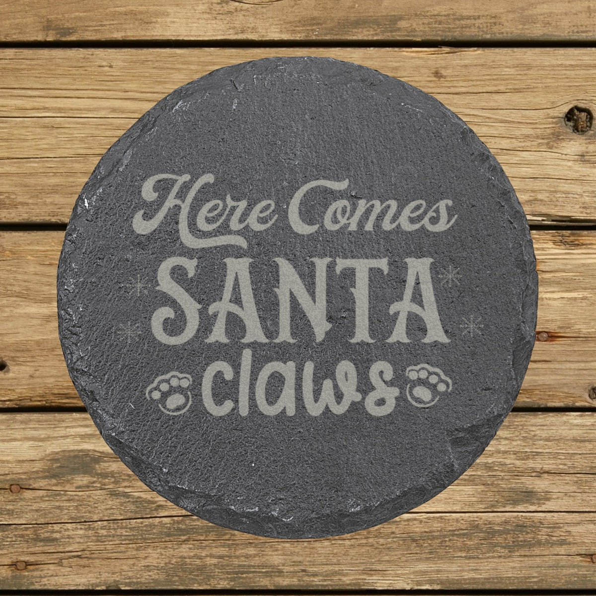 Round slate coaster laser engraved with "Here Comes Santa Claws"