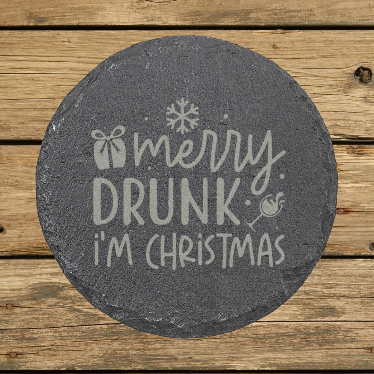 Round slate coaster laser engraved with "Merry Drunk I'm Christmas"