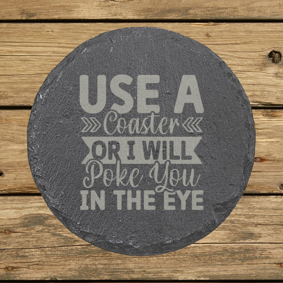 Round slate coaster laser engraved with "Use a Coaster or I Will Poke You in the Eye", hand lettered design