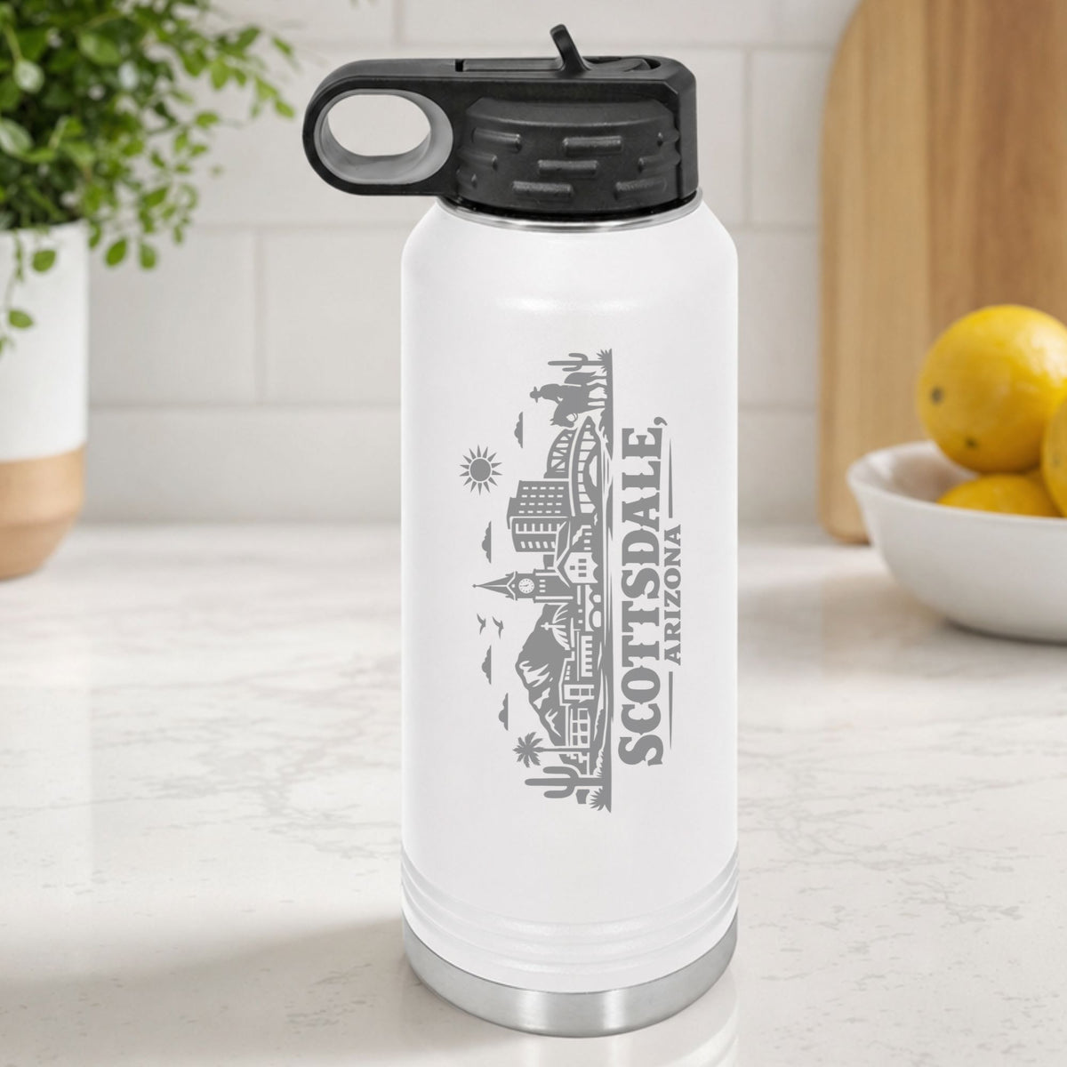 White 32 oz insulated water bottle laser engraved with the Scottsdale, Arizona skyline running up the side, standing on a kitchen counter