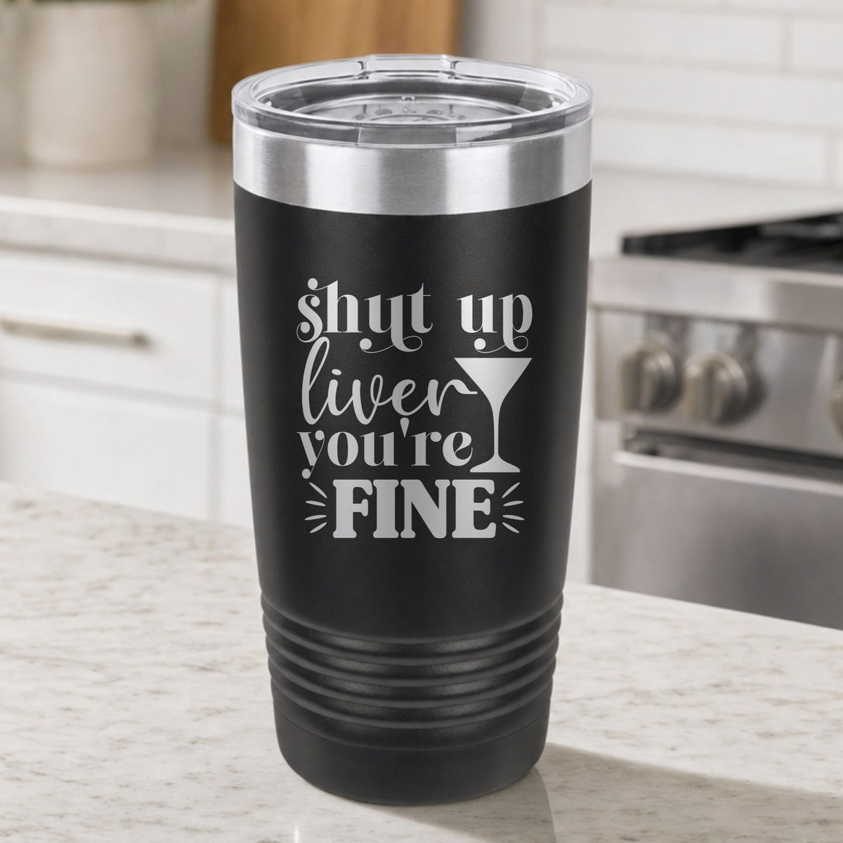 Black 20 oz tumbler laser engraved with "Shut Up Liver, You're Fine", on a kitchen counter