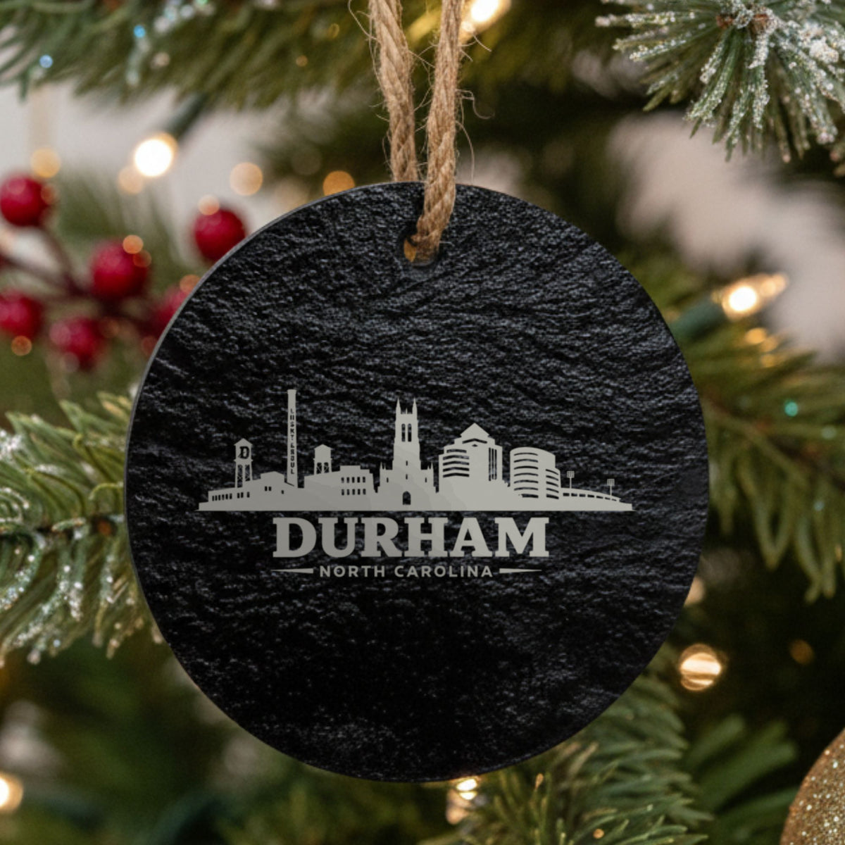 Durham, North Carolina skyline engraved on a round slate Christmas ornament