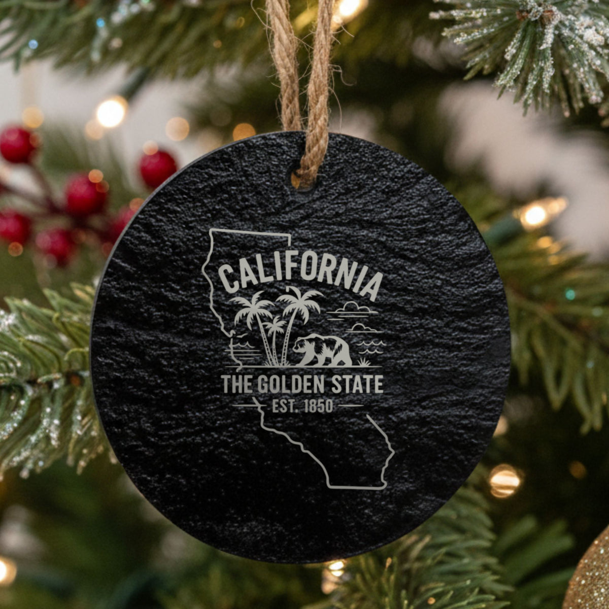 Round slate Christmas ornament laser engraved with a California design of palm trees, the ocean and a grizzly bear