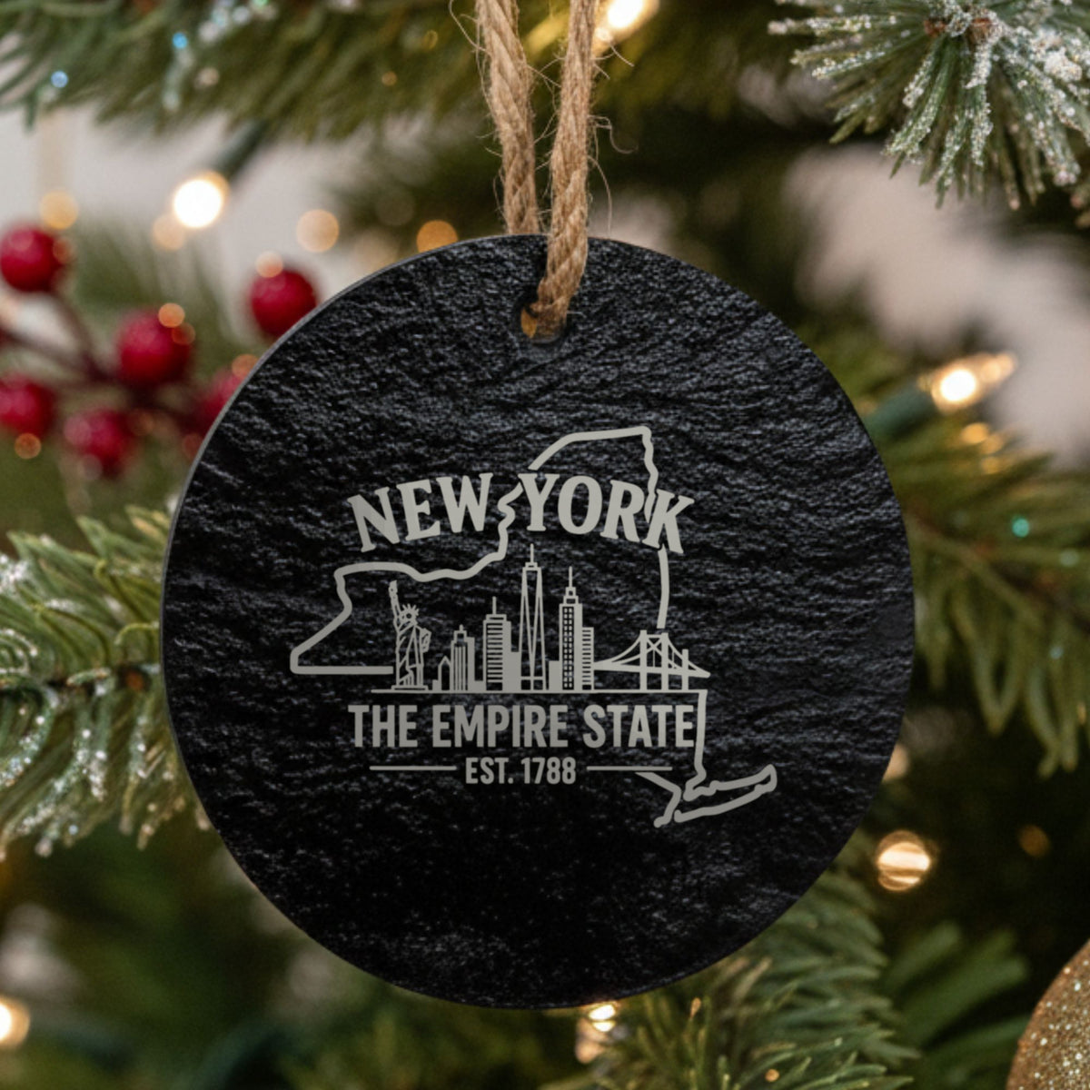 Round slate Christmas ornament laser engraved with a New York design of the Statue of Liberty and the Manhattan skyline