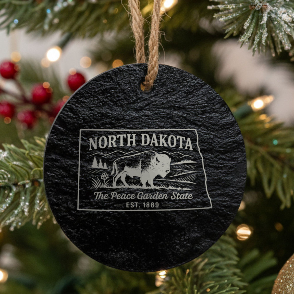 Round slate Christmas ornament laser engraved with a North Dakota design of a bison on the plains