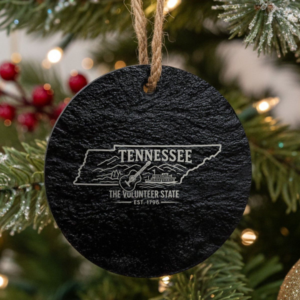 Round slate Christmas ornament laser engraved with a Tennessee design of a guitar, a riverboat and the Smoky Mountains