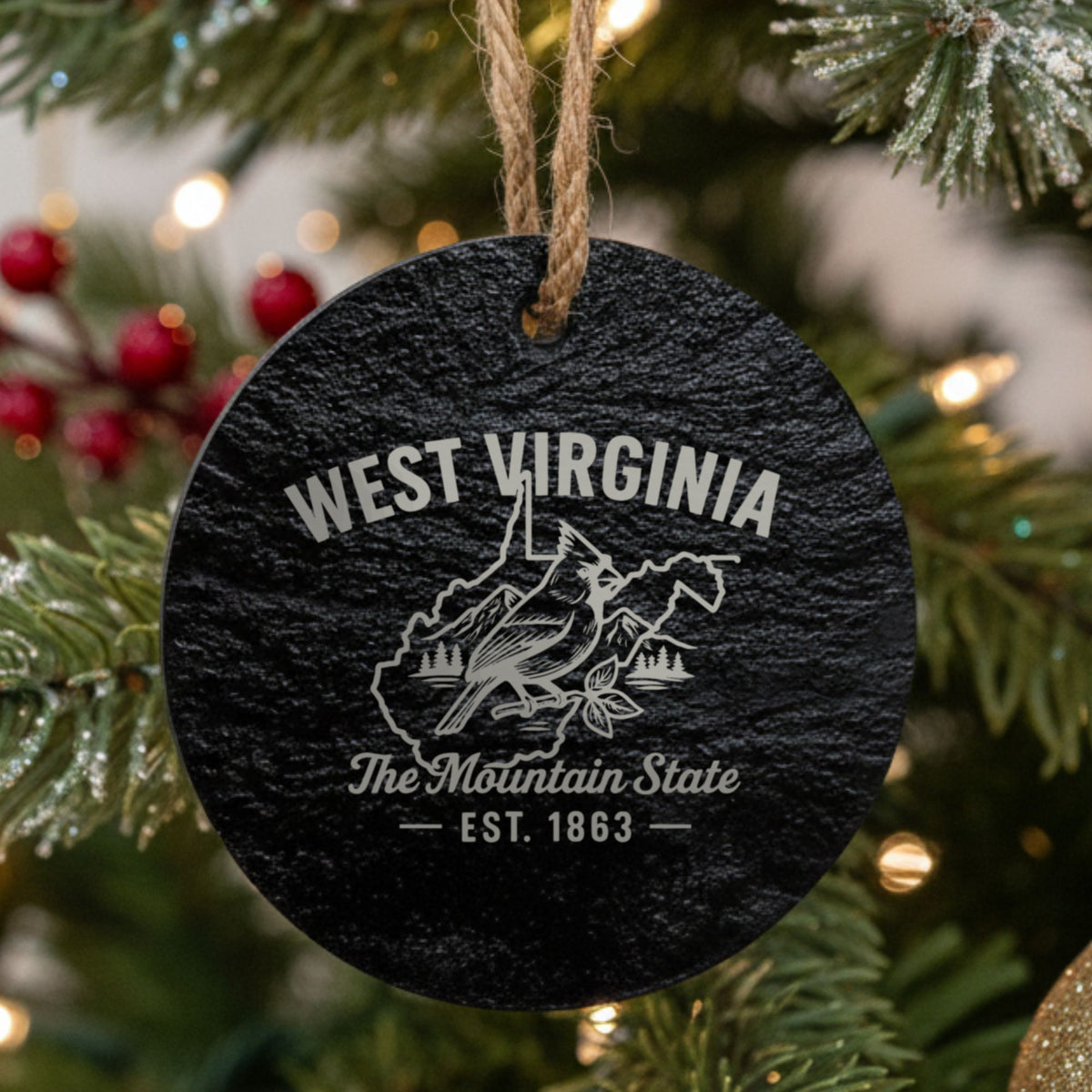 Round slate Christmas ornament laser engraved with a West Virginia design of a cardinal, mountains and pines