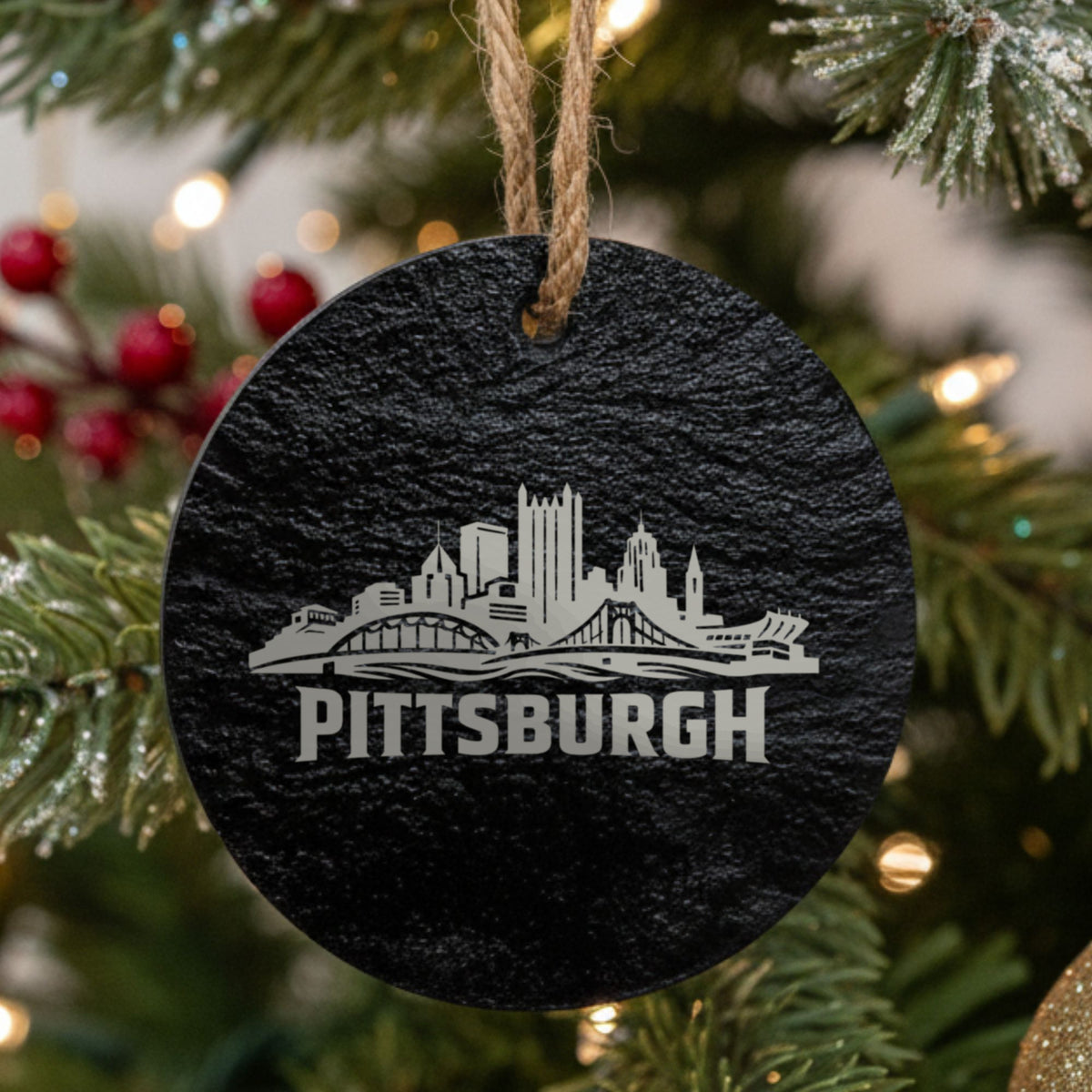 Pittsburgh, Pennsylvania skyline engraved on a round slate Christmas ornament