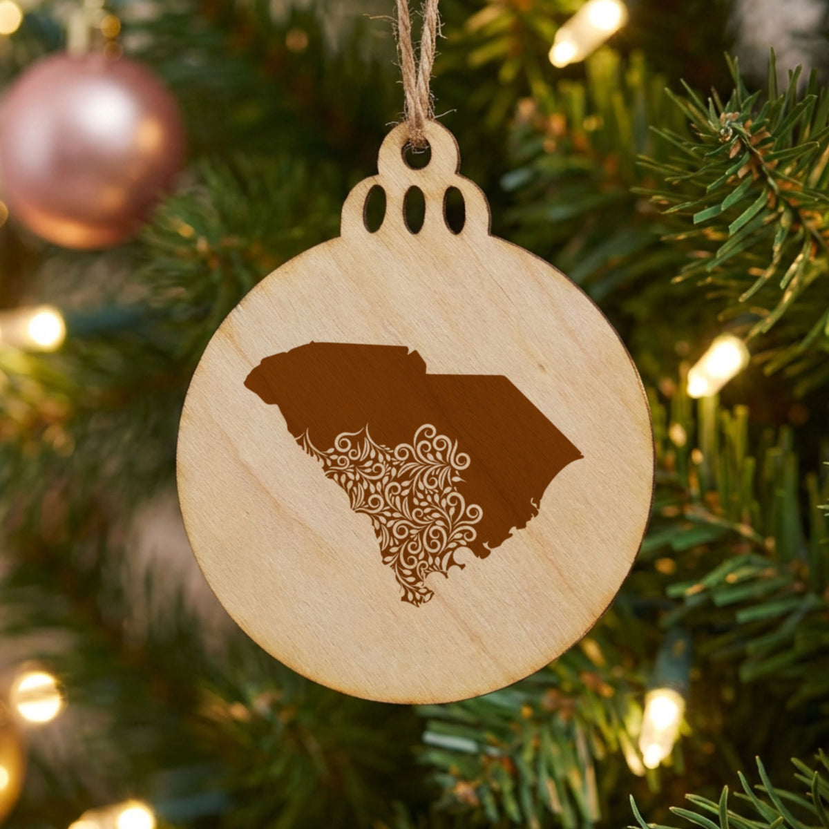 South Carolina round wood Christmas ornament engraved with the state shape in ornate floral scrollwork