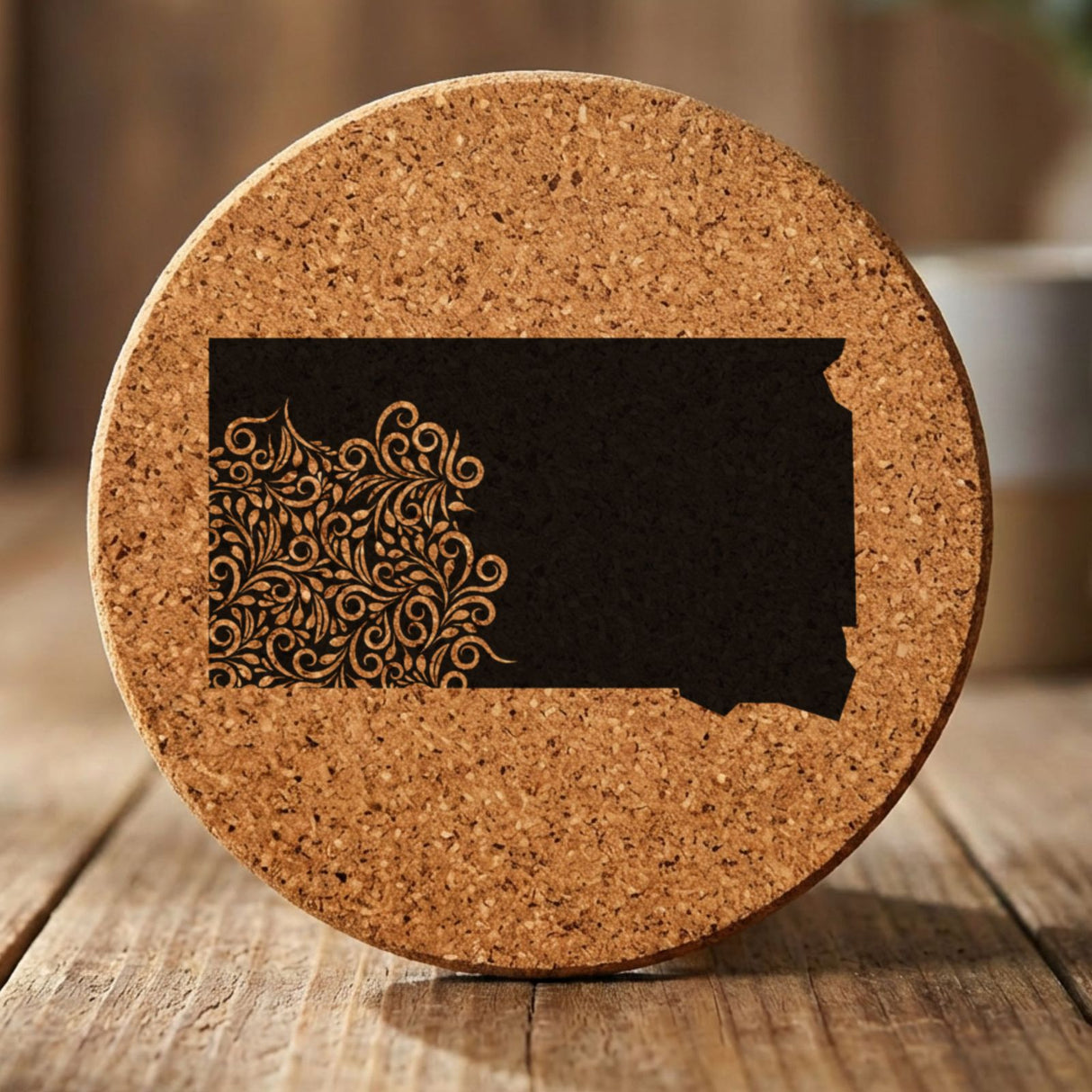 South Dakota round cork coaster engraved with the state shape in ornate floral scrollwork