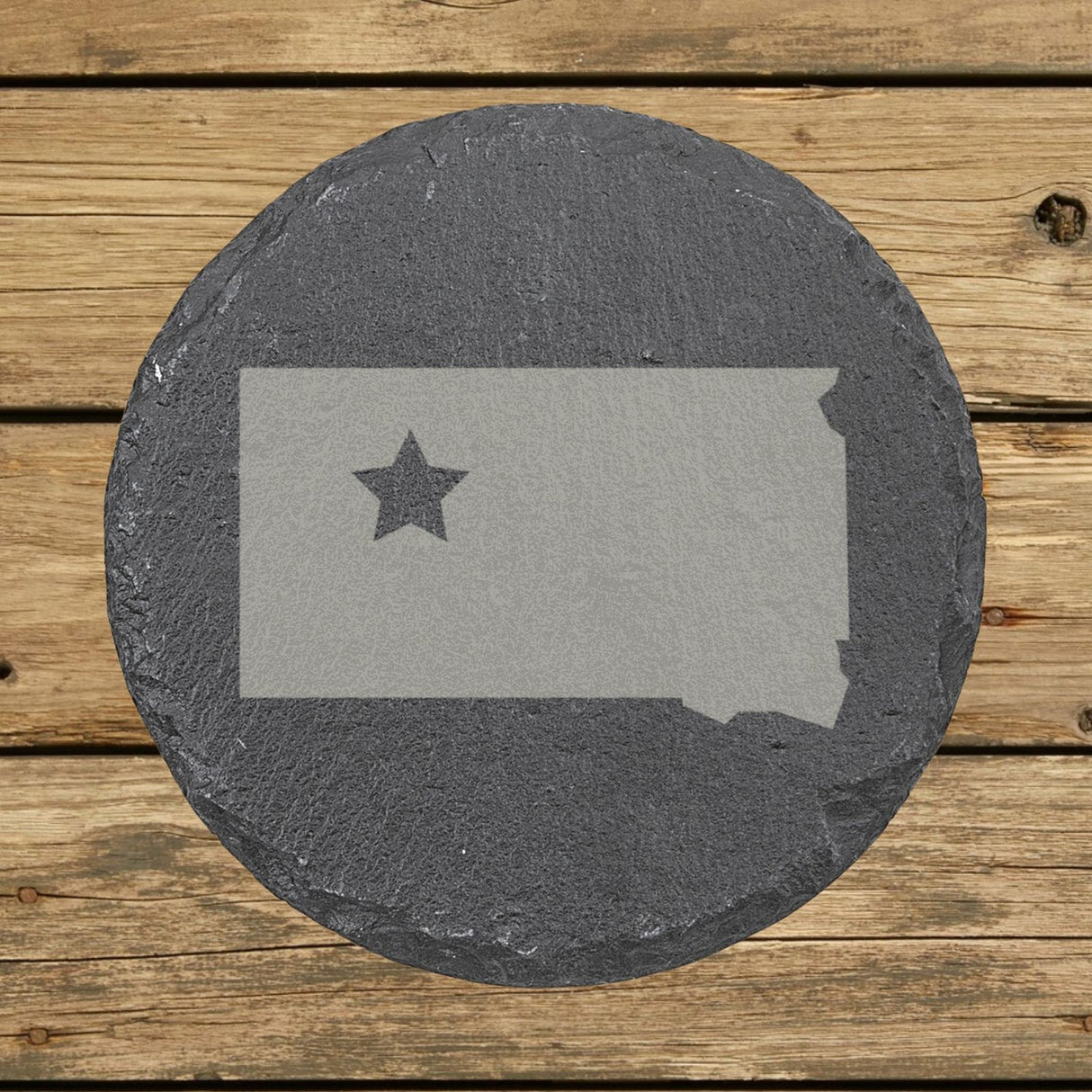 South Dakota round slate coaster engraved with the state shape and a star