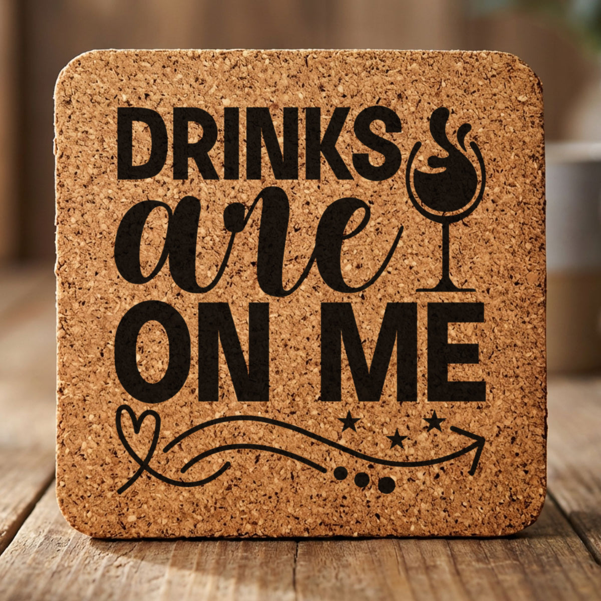 Square cork coaster laser engraved with "Drinks Are On Me", wine glass design