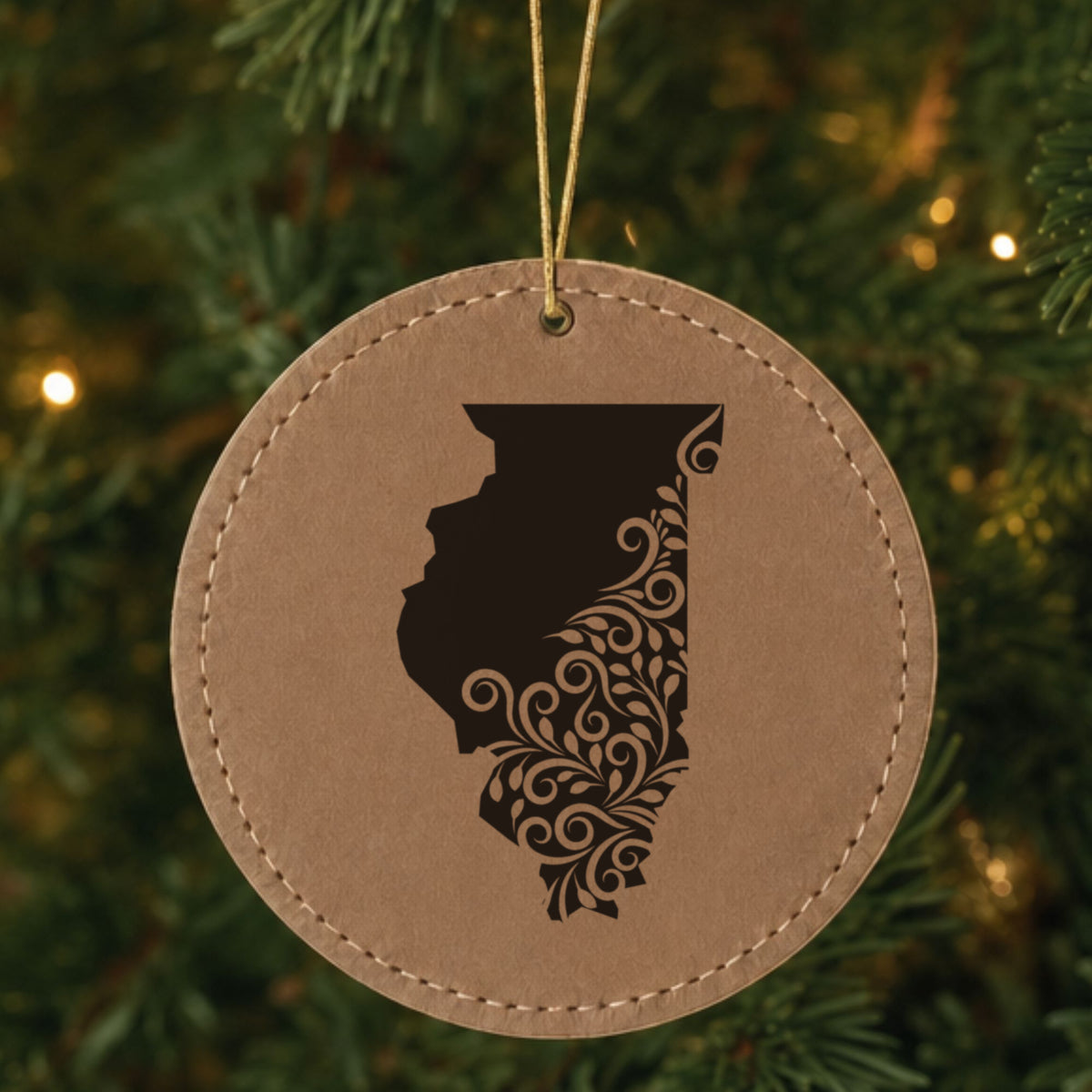 Brown leatherette round Christmas ornament laser engraved with the Illinois Floral Damask design, hanging on a tree