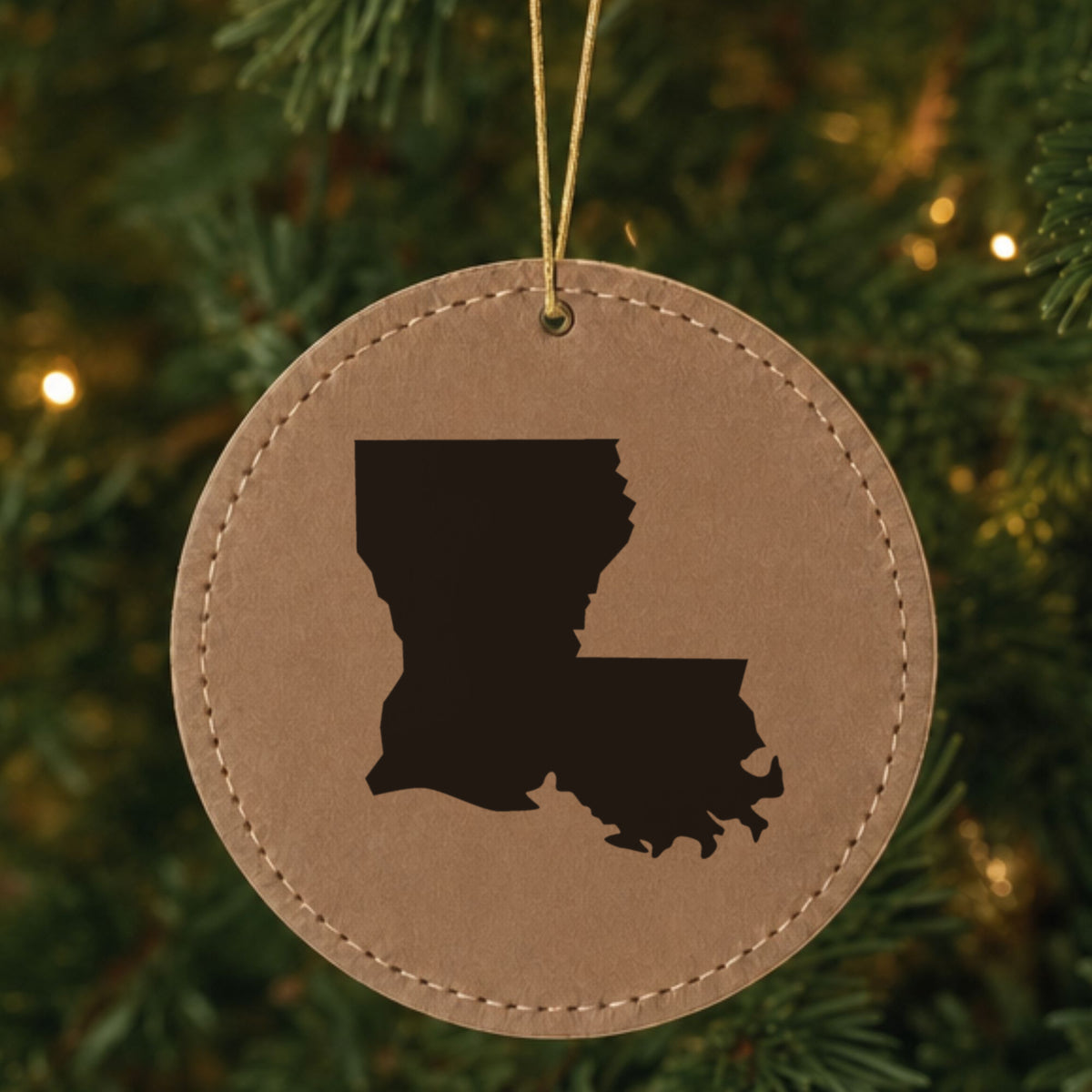 Brown leatherette round Christmas ornament laser engraved with the Louisiana Engraved State design, hanging on a tree