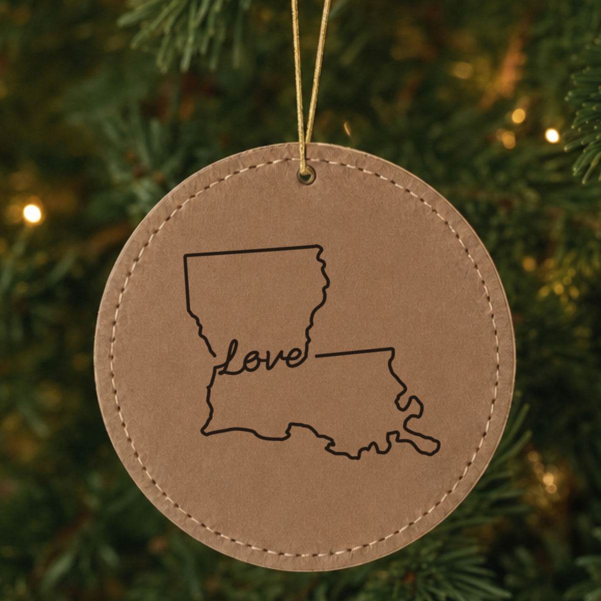Brown leatherette round Christmas ornament laser engraved with the Louisiana Hand-Drawn Love design, hanging on a tree