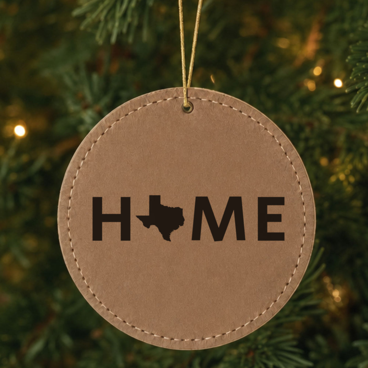 Brown leatherette round Christmas ornament laser engraved with the Texas HOME Outline design, hanging on a tree