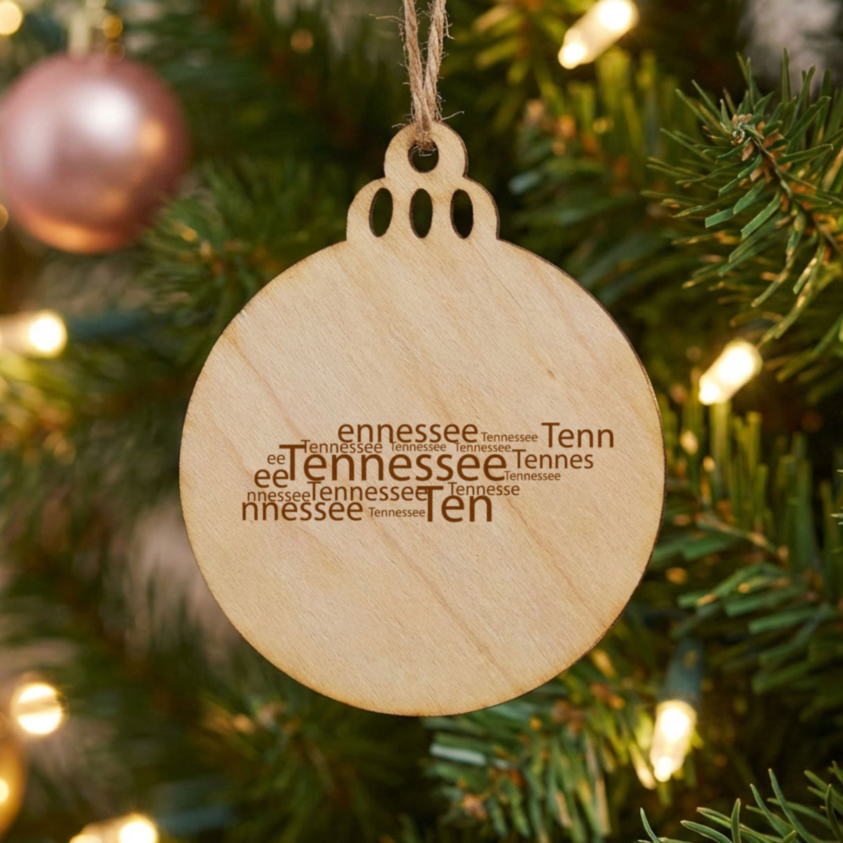Tennessee round wood Christmas ornament engraved with a word cloud of repeating Tennessee text