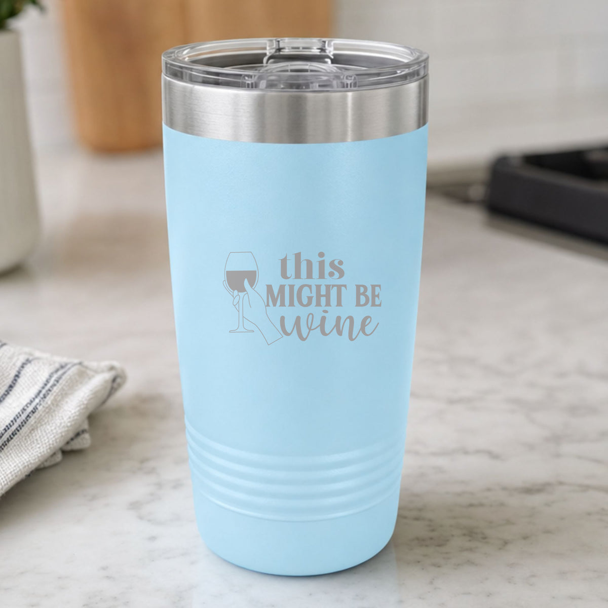 Light Blue 20 oz tumbler laser engraved with "This Might Be Wine", on a kitchen counter