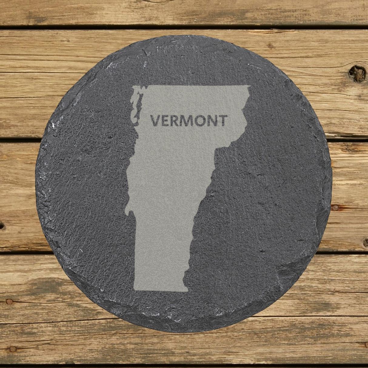Vermont round slate coaster engraved with the state shape and VERMONT in bold lettering