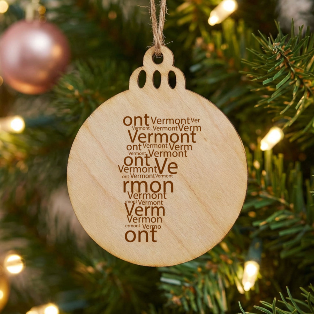 Vermont round wood Christmas ornament engraved with a word cloud of repeating Vermont text
