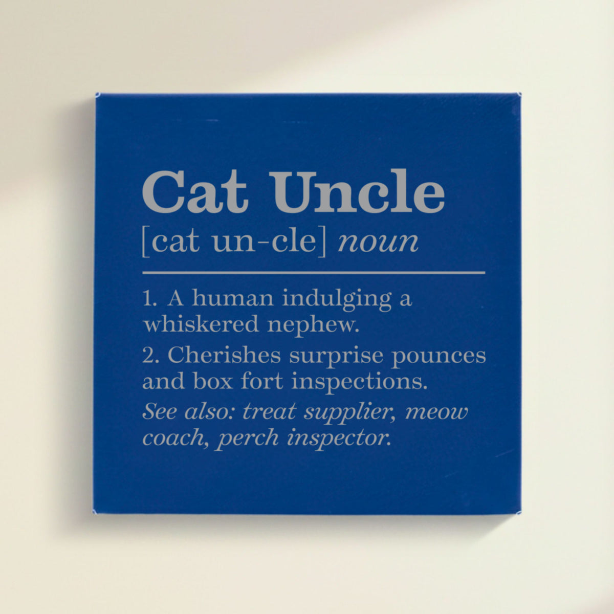 Close-up of the blue leatherette wall sign engraved with the Cat Uncle dictionary definition