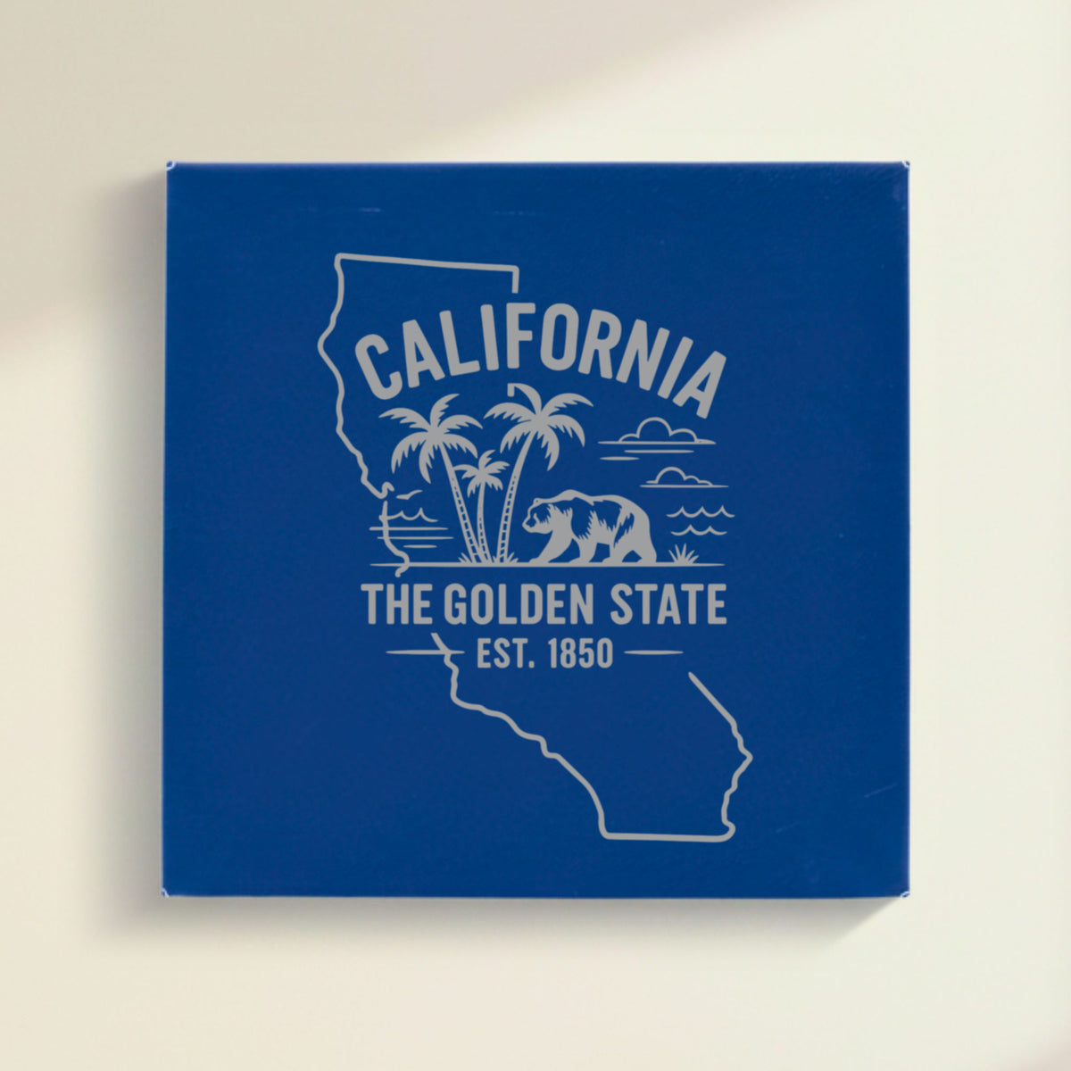 Close up of the California design engraved on Blue leatherette: palm trees, the ocean and a grizzly bear, "The Golden State", EST. 1850