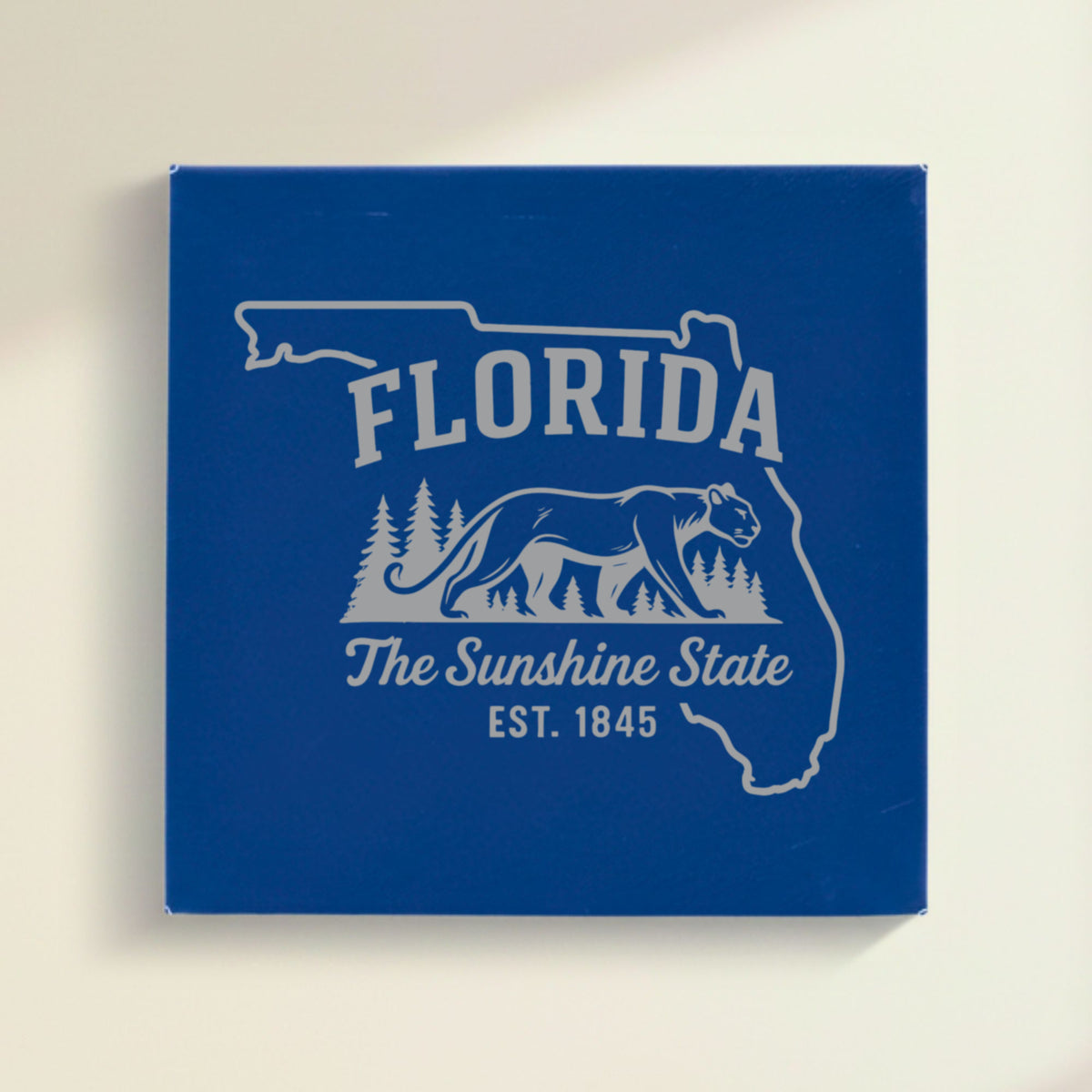 Close up of the Florida design engraved on Blue leatherette: a Florida panther and pine forest, "The Sunshine State", EST. 1845