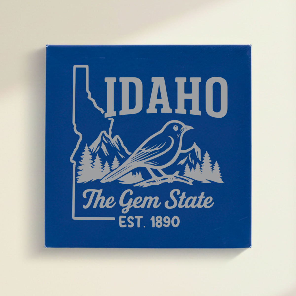 Close up of the Idaho design engraved on Blue leatherette: a mountain bluebird, mountains and pines, "The Gem State", EST. 1890