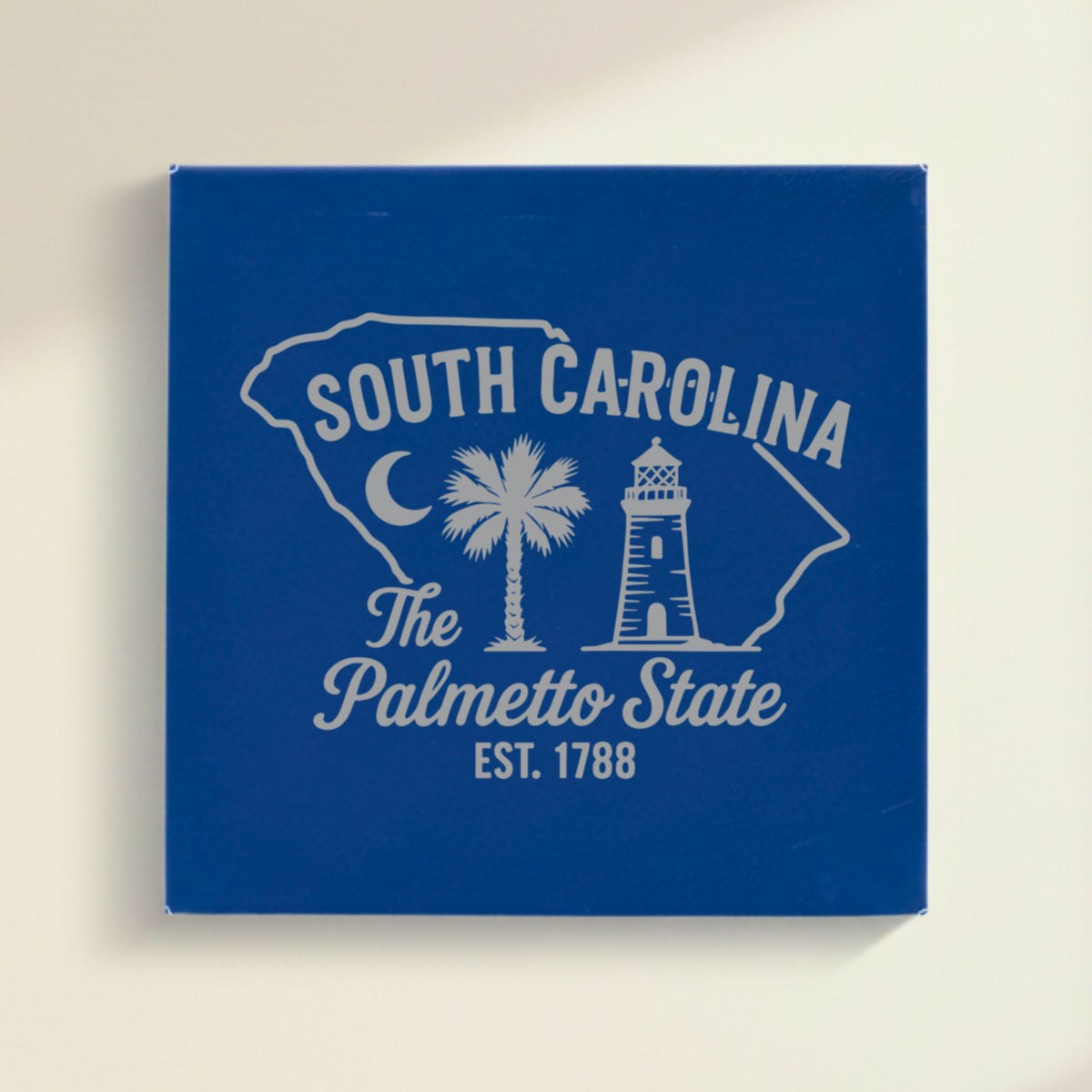 Close up of the South Carolina design engraved on Blue leatherette: a crescent moon, a palmetto tree and a lighthouse, "The Palmetto State", EST. 1788