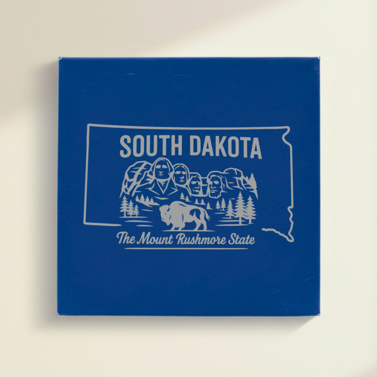 Close up of the South Dakota design engraved on Blue leatherette: Mount Rushmore and a bison, "The Mount Rushmore State"