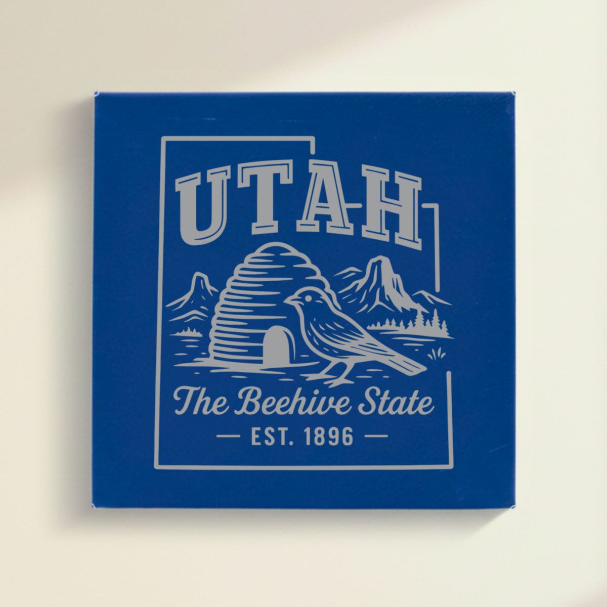 Close up of the Utah design engraved on Blue leatherette: a beehive, a California gull and red rock arches, "The Beehive State", EST. 1896